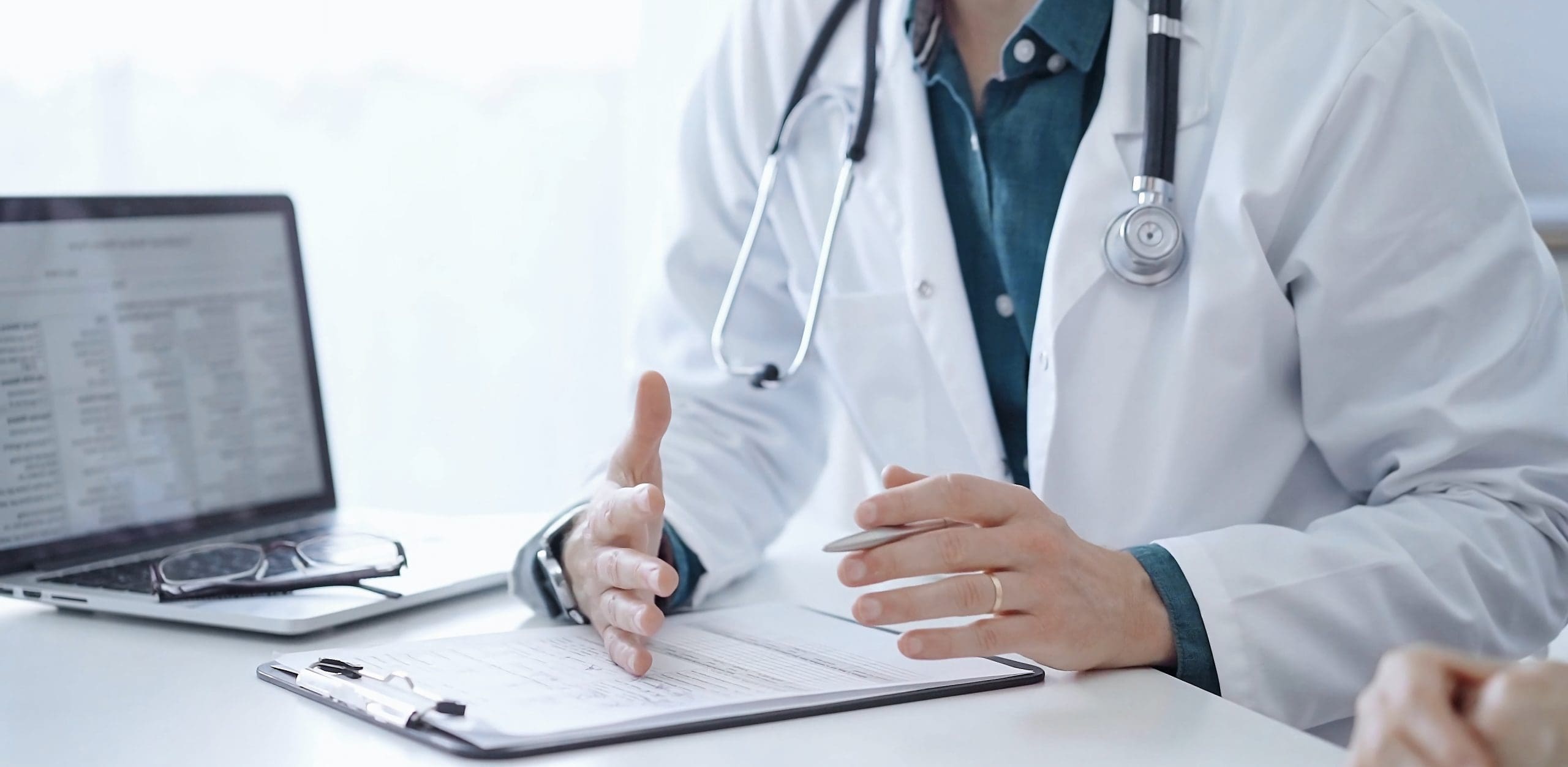 DoctorAndAPatientThePhysicianWearingAWhiteMedical DoctorAndAPatientThePhysicianWearingAWhiteMedical